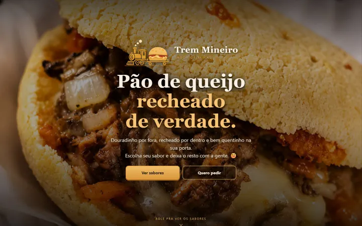 Topo do site do Trem Mineiro no computador: um pão de queijo recheado ocupando a tela inteira, com a marca e os botões por cima